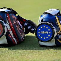 Mehrere Golfsäcke mit Aufdrucken USA und Europa liegen auf einem grünen Rasen.